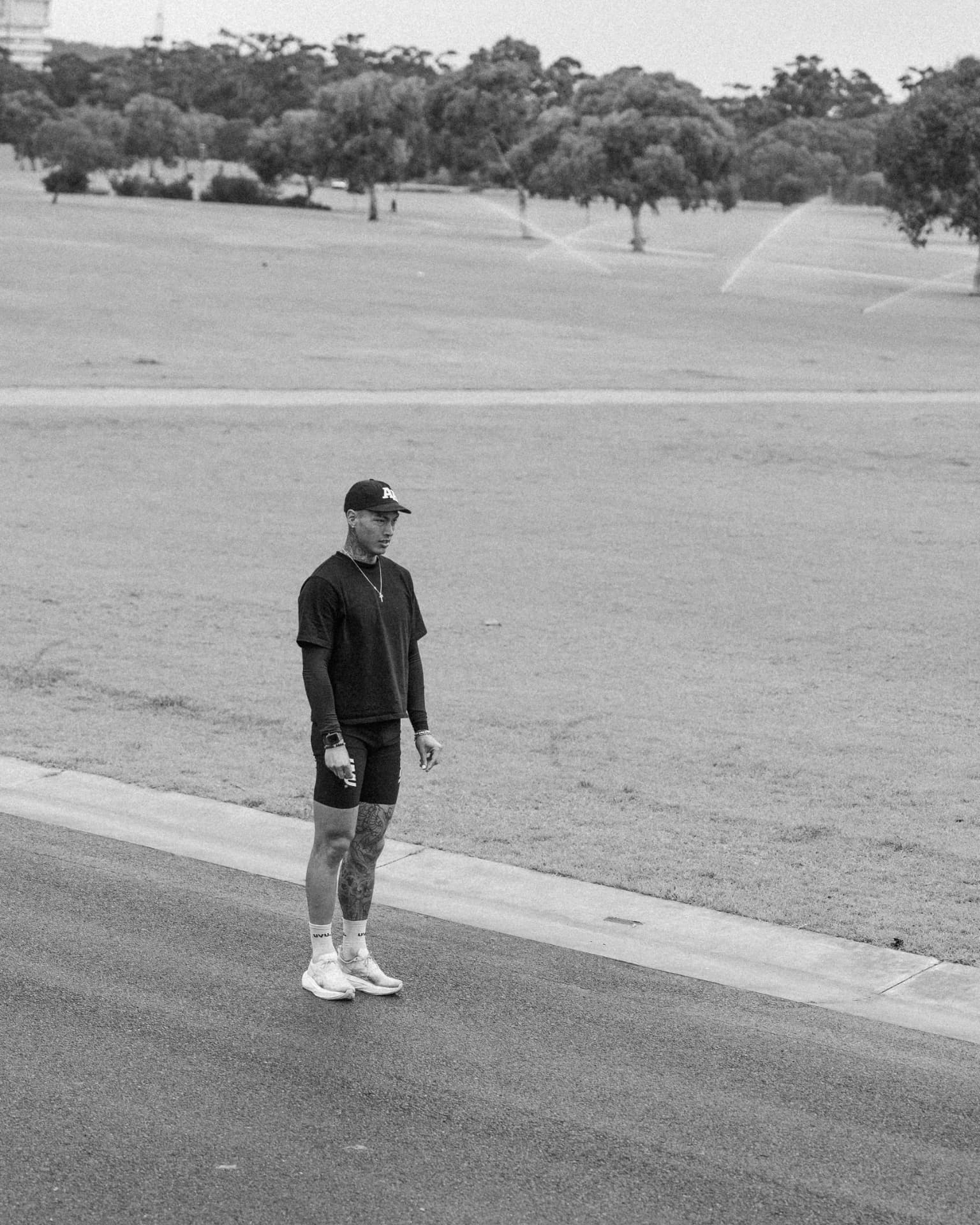 Runner standing on a wide open park road