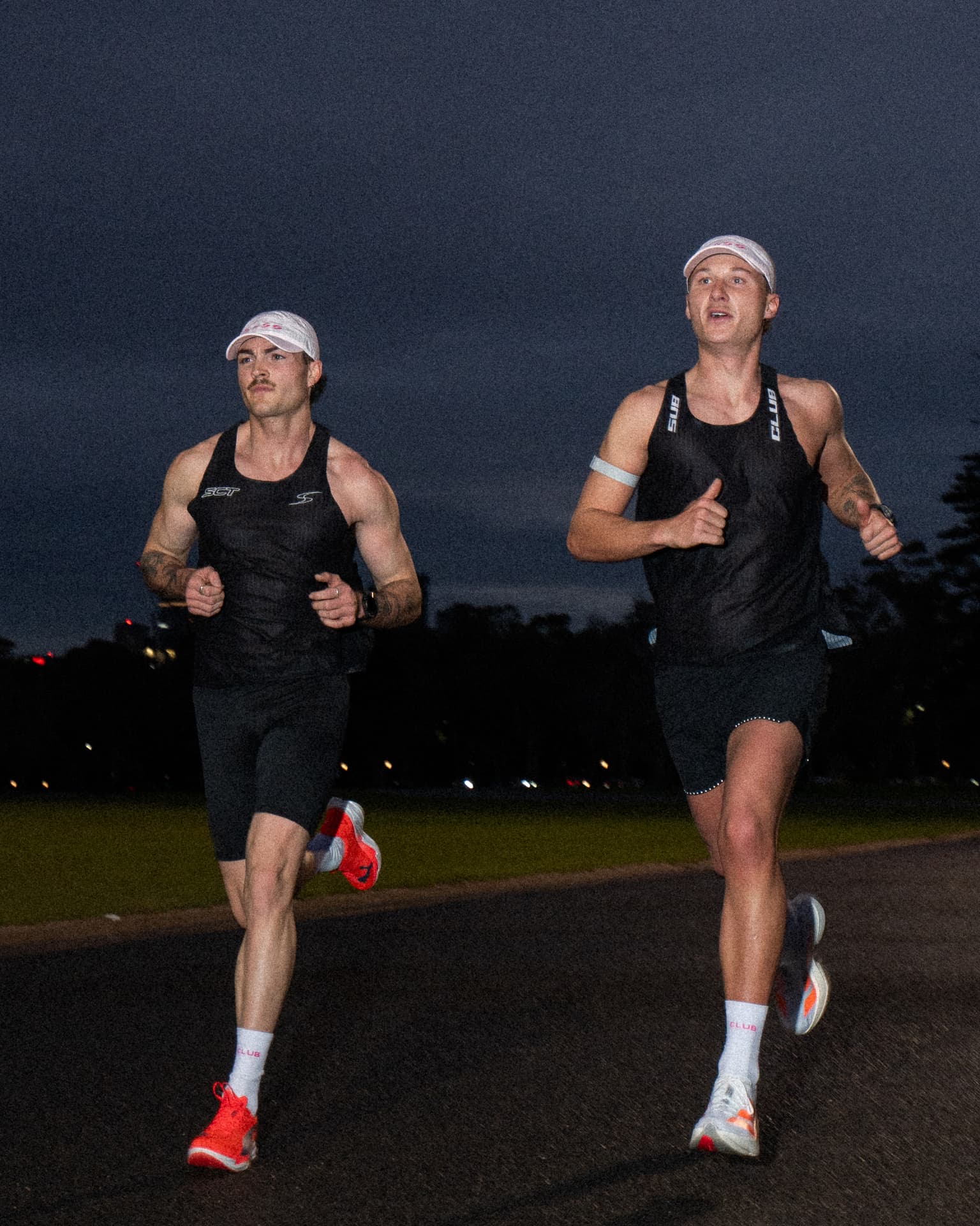 Two runners at dusk under a deep blue sky