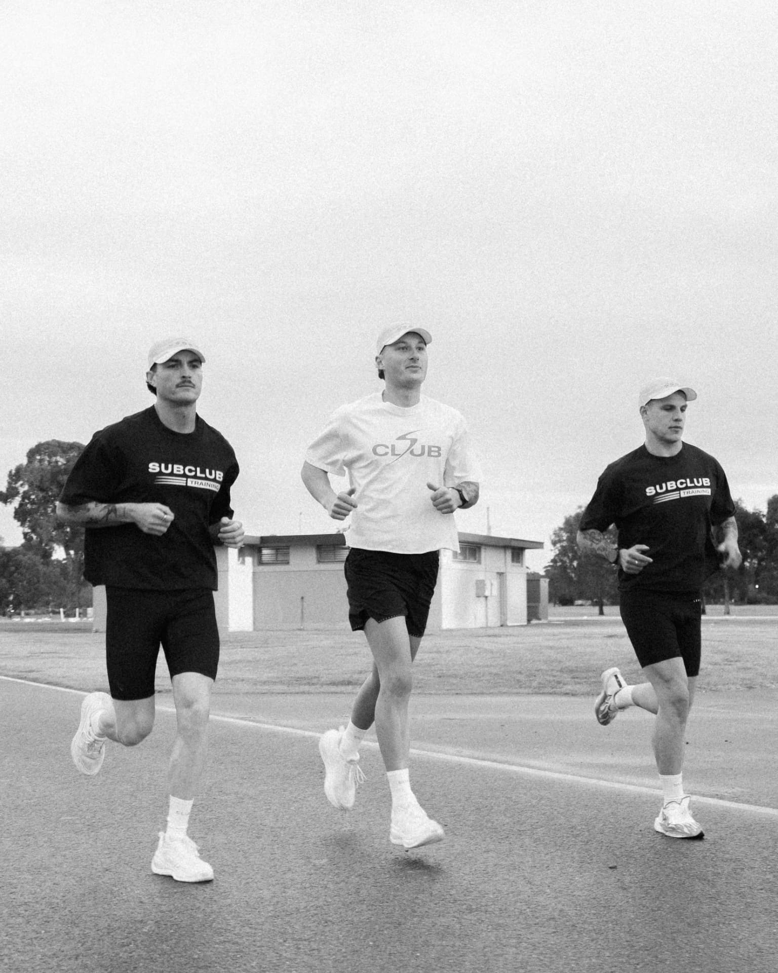 Three Subclub runners side by side on an overcast road