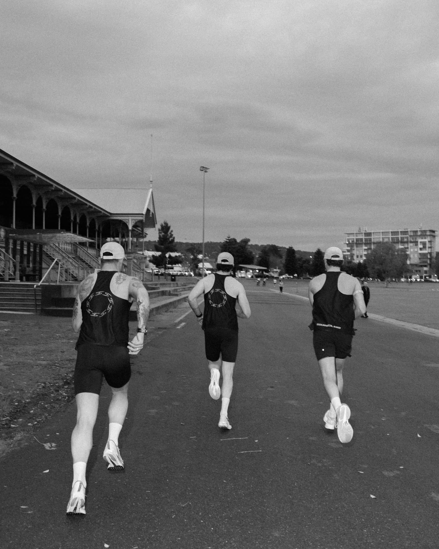 Three runners from behind heading down the esplanade