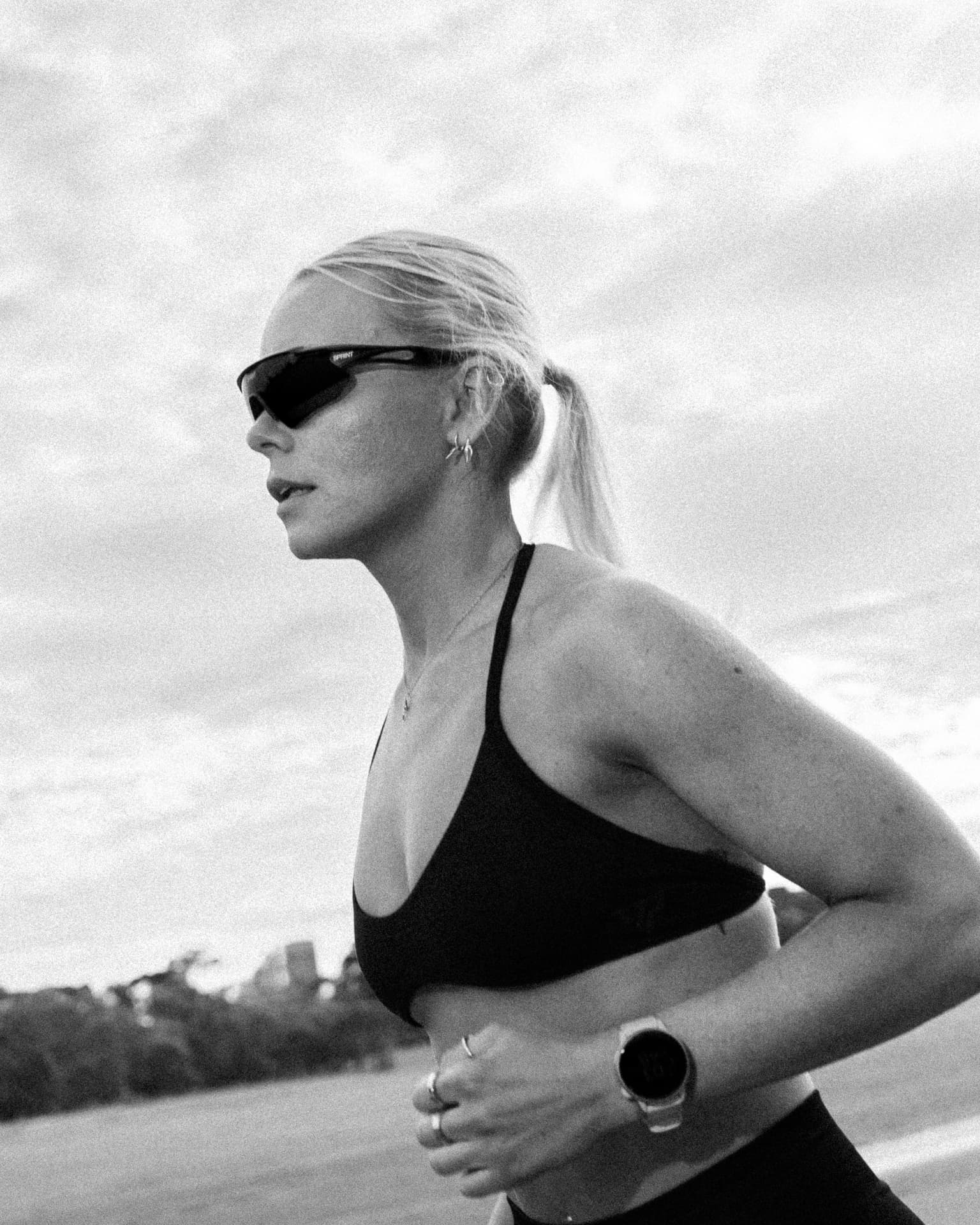 Black and white frame of a runner against open sky