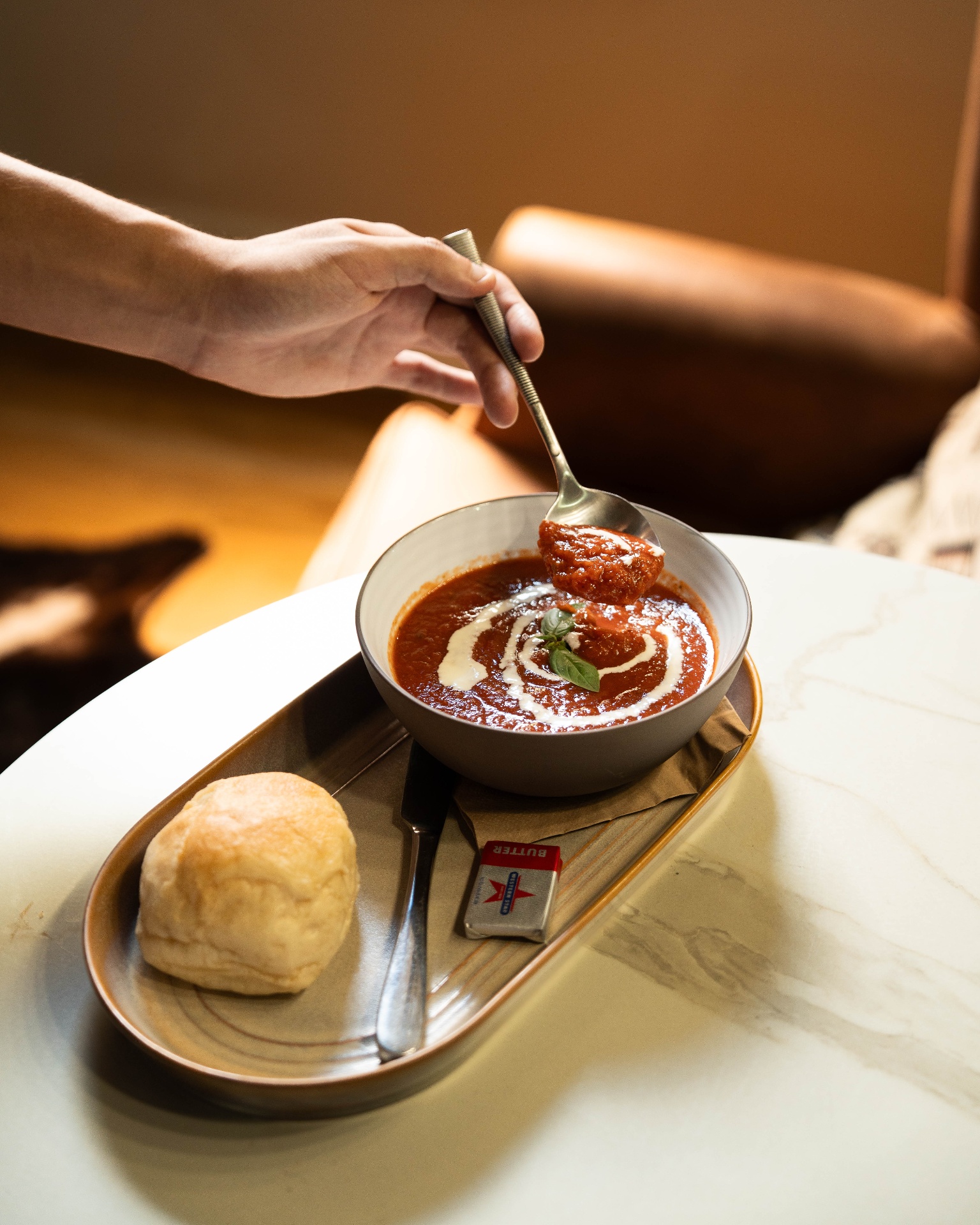 Tomato soup with crème fraîche and bread roll