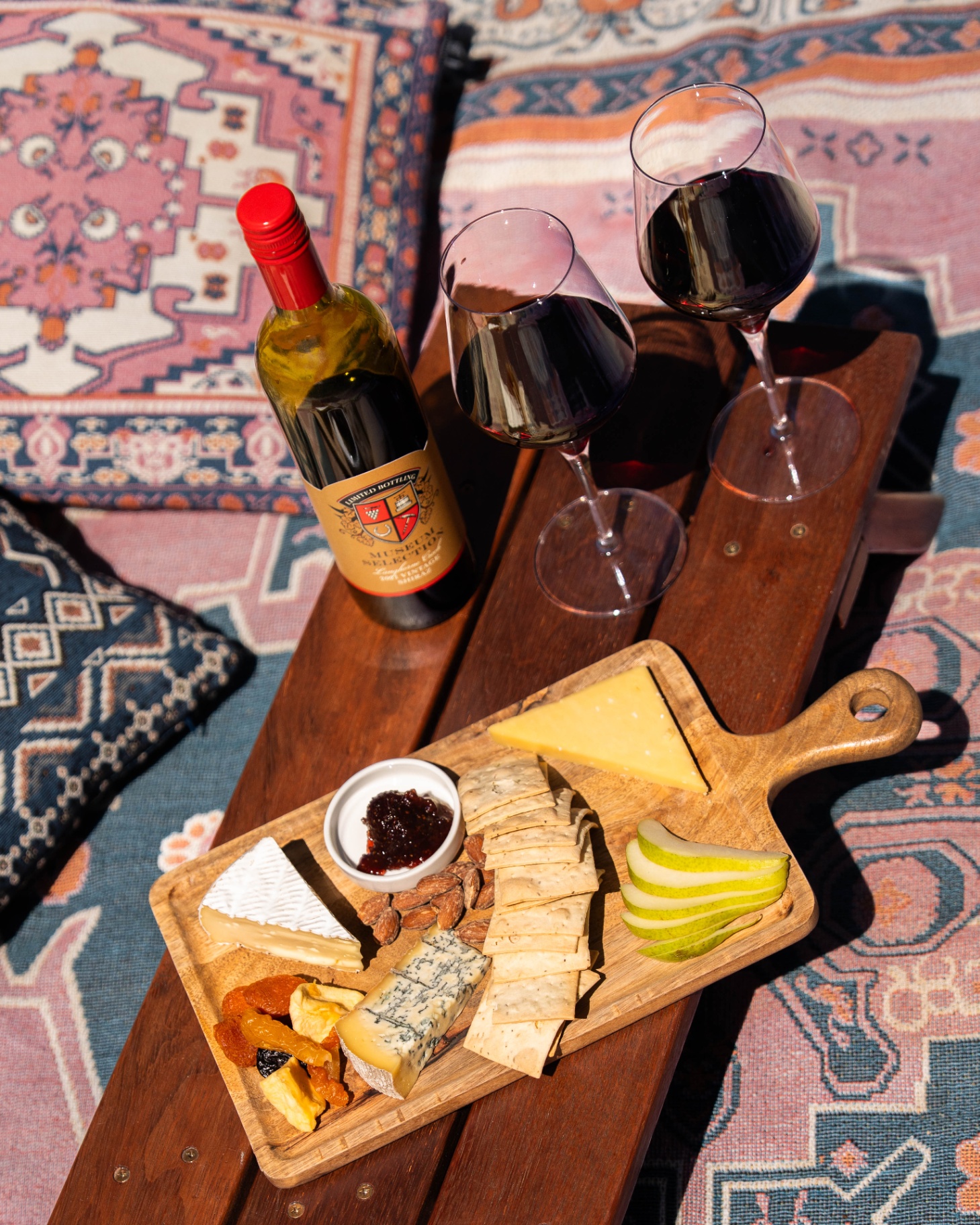 Cheese board and red wine on a Persian rug