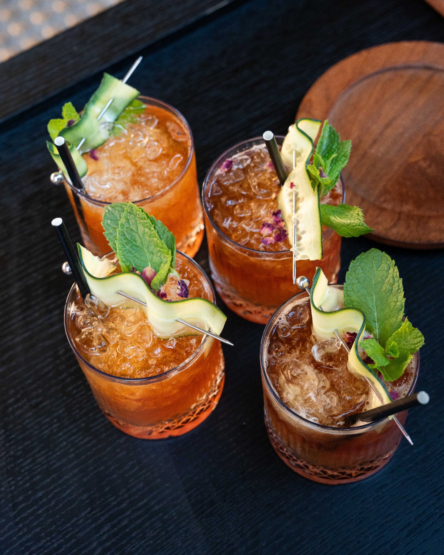 Garnished cocktails on a dark bar tray