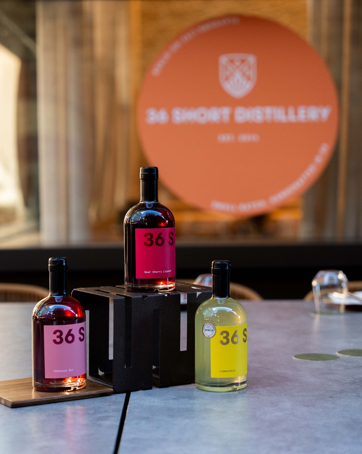 36 Short Distillery bottles staged in front of the venue's signage