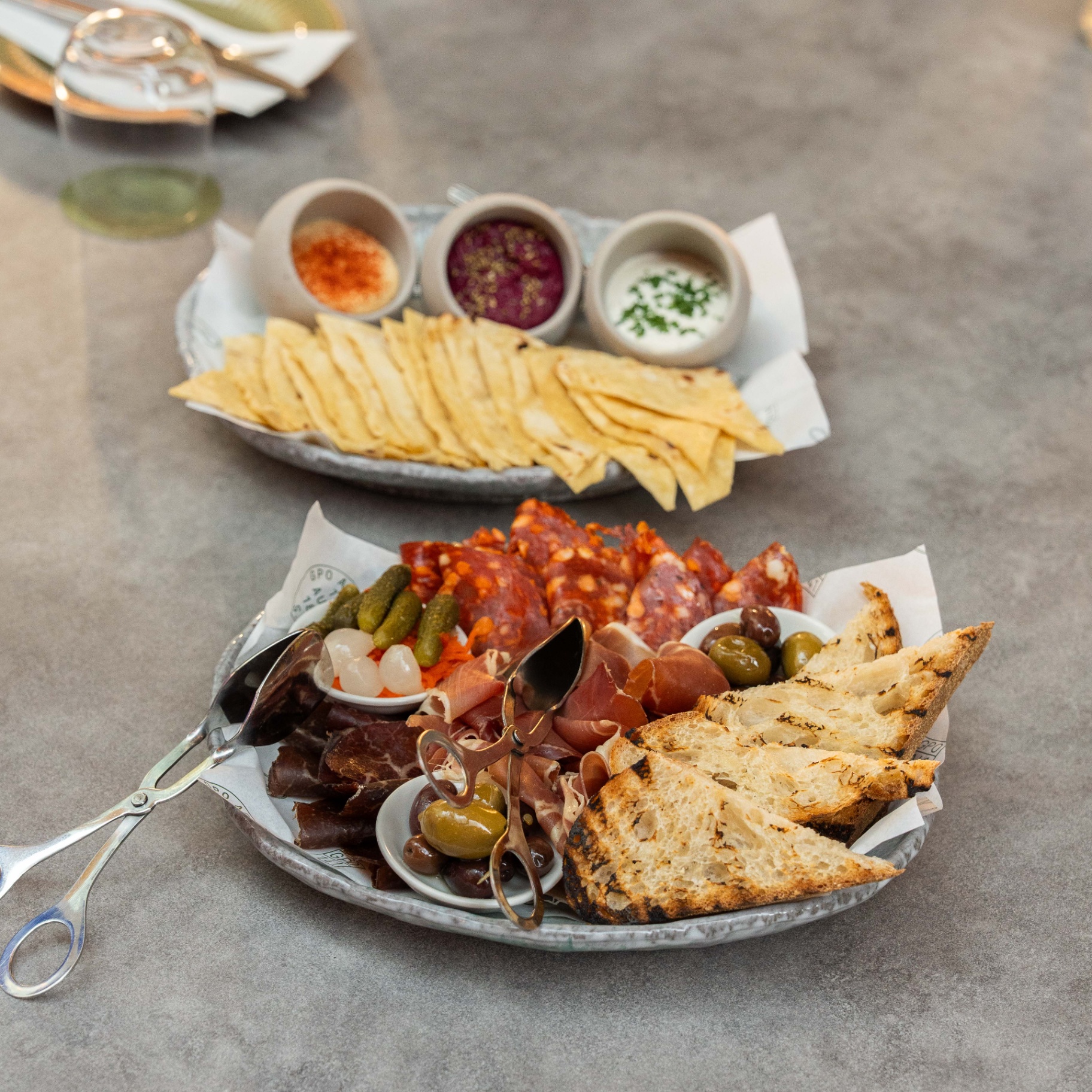 Charcuterie board with cured meats, olives and dips