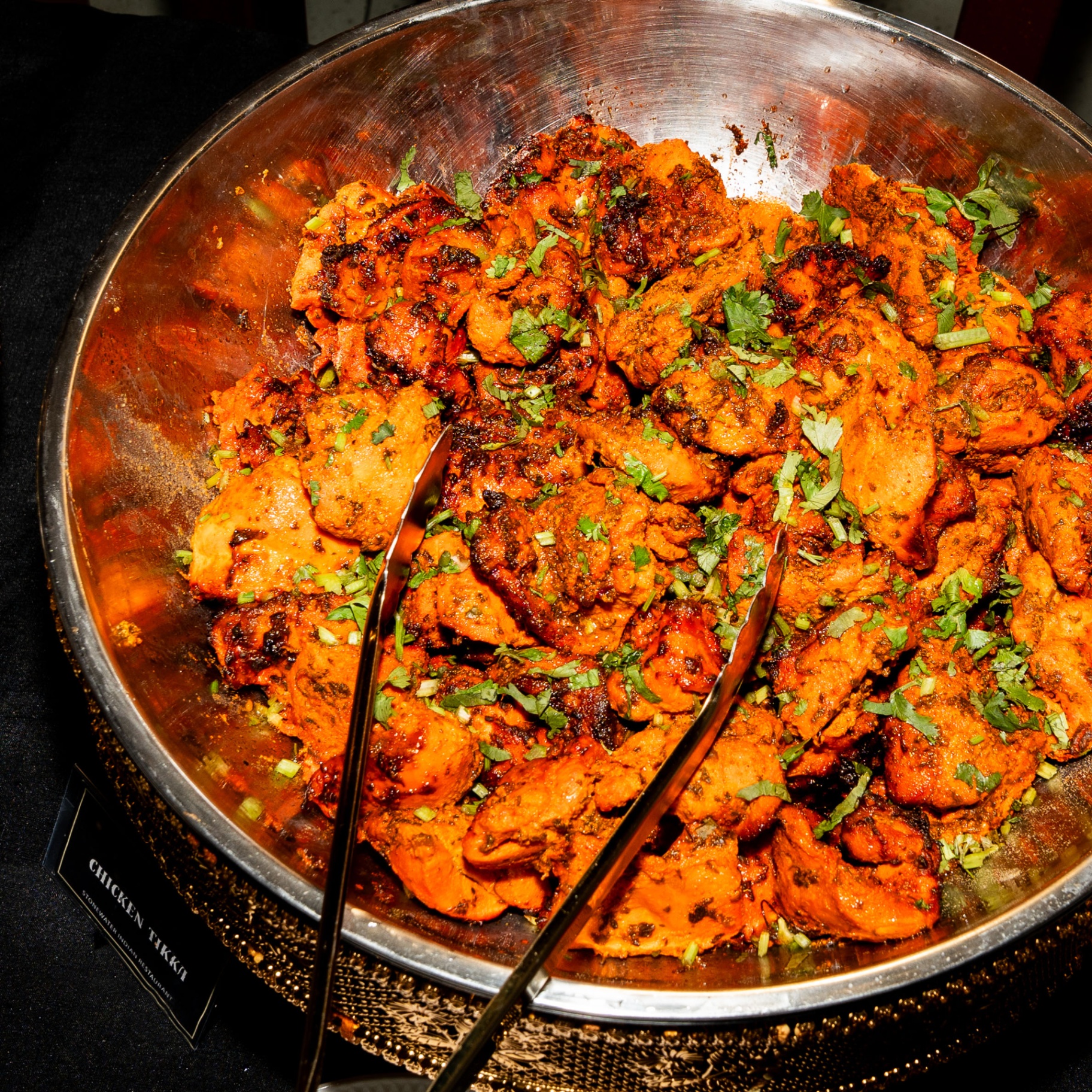 Chicken tikka in a copper bowl with coriander