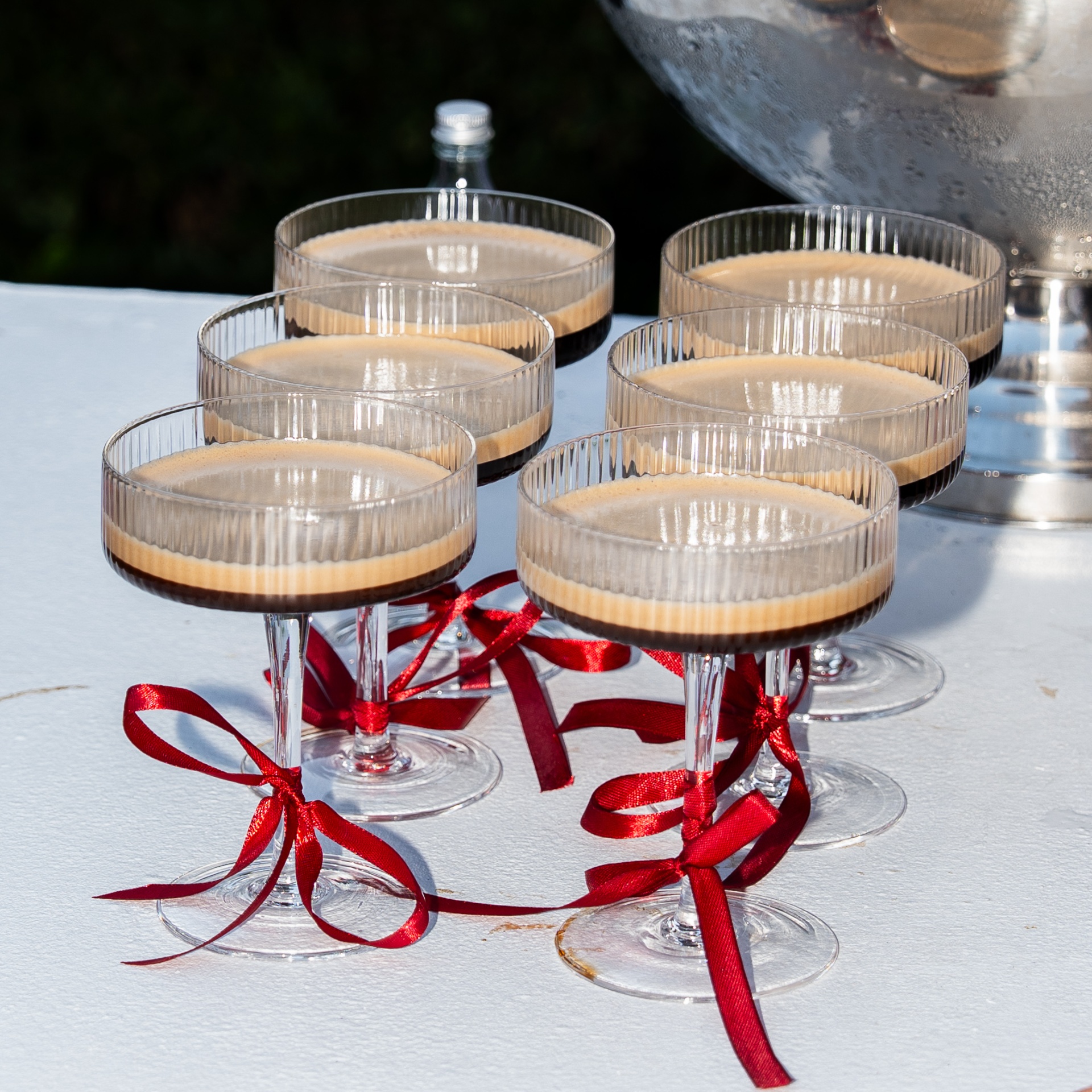 Espresso martinis in fluted coupes with red ribbons
