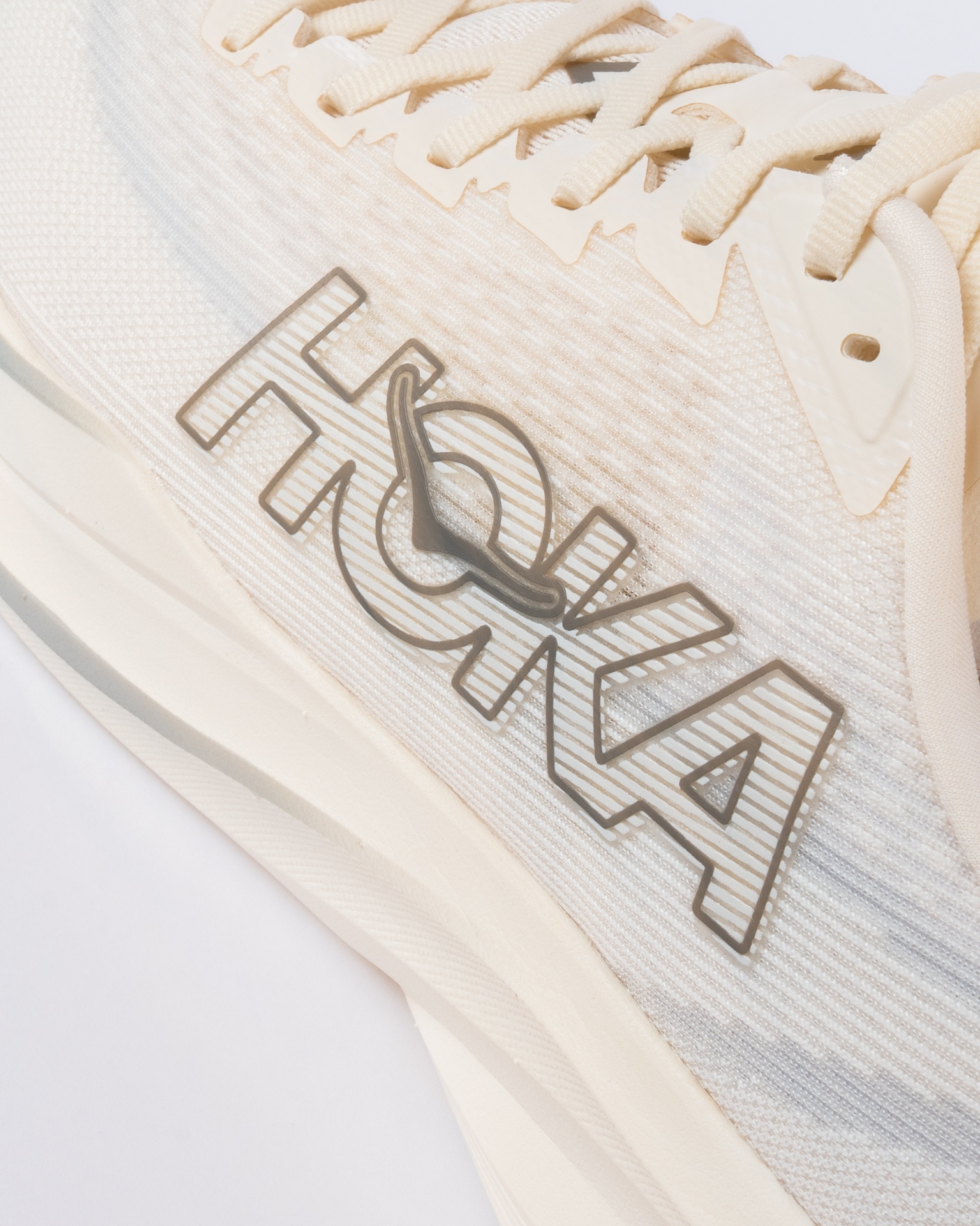 Macro close-up of the HOKA outline logo on woven mesh