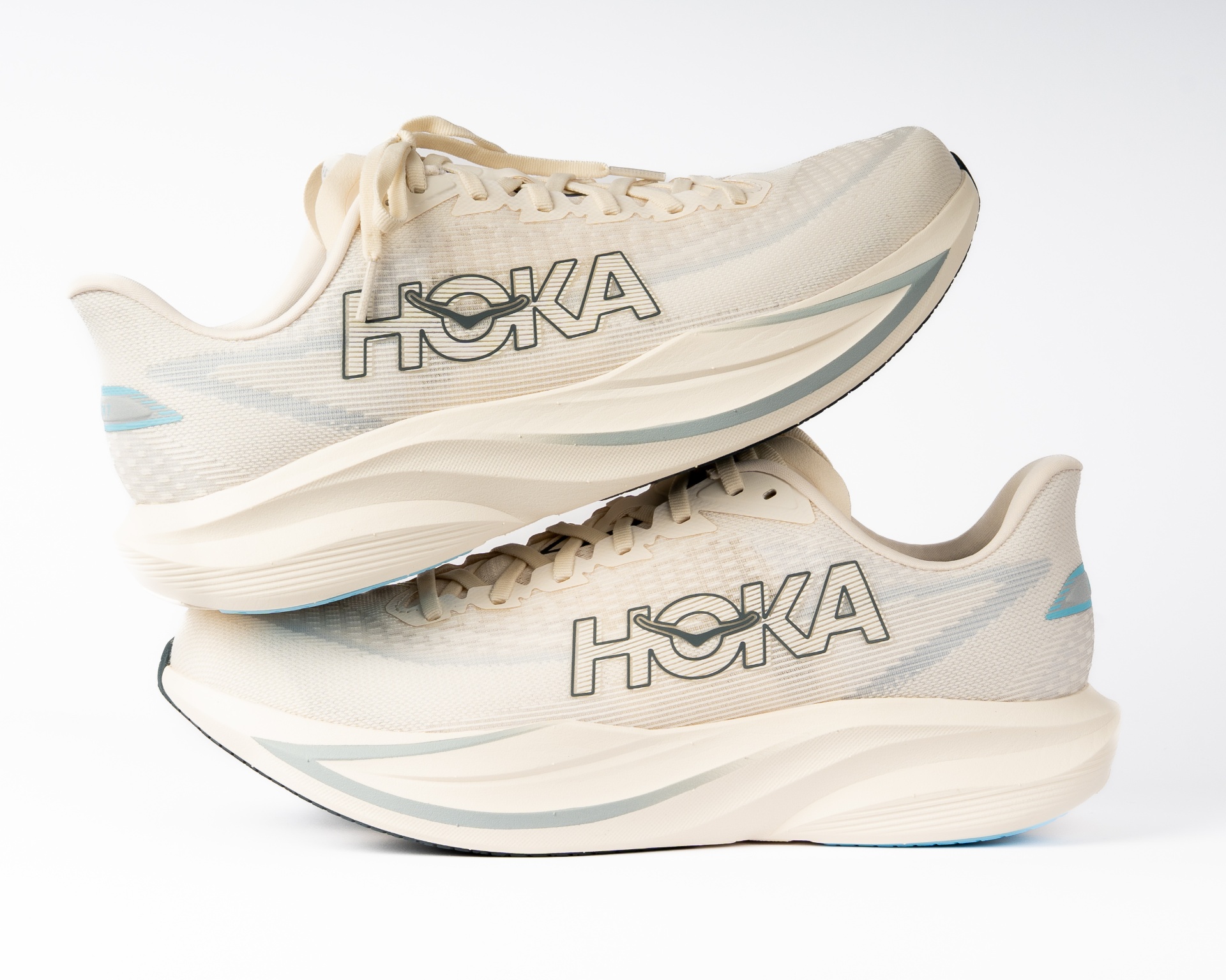 Pair of cream HOKA running shoes stacked on a white background