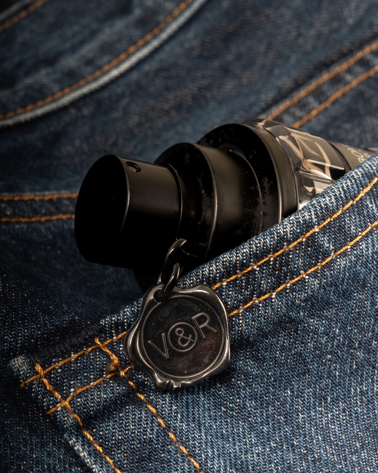 Spicebomb bottle tucked into a denim pocket with the V&R wax seal charm