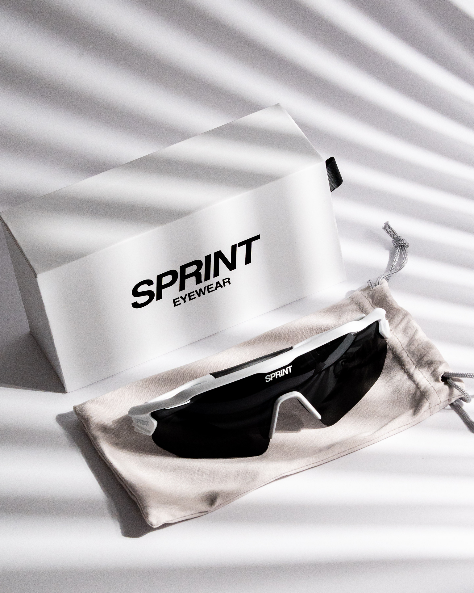 Sprint Eyewear box and sunglasses on pouch with linear shadows
